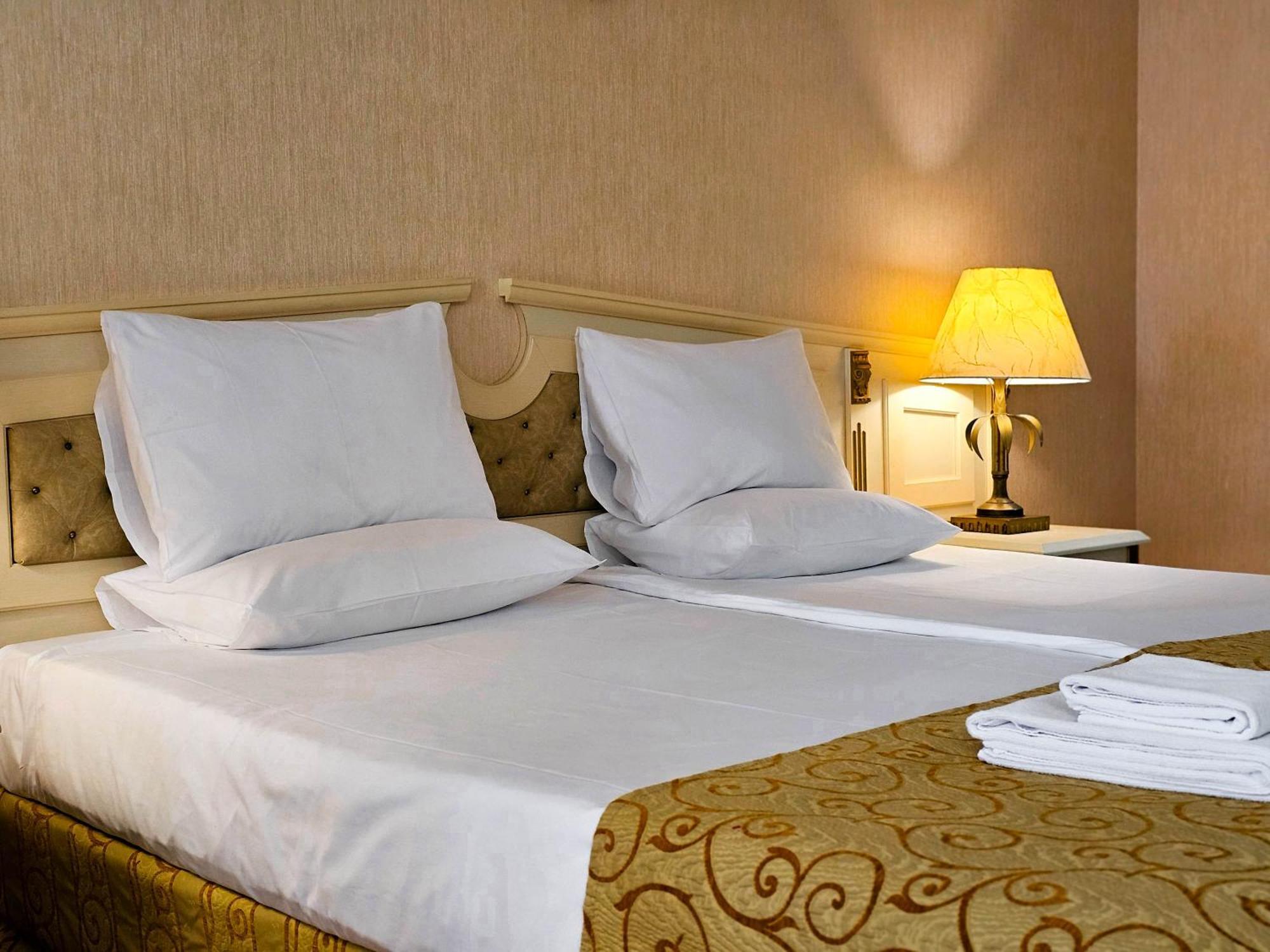 Imperial Palace Hotel ซันนีบีช ภายนอก รูปภาพ A bed with pillows and a lamp